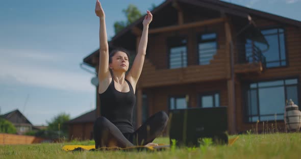 Young Athletic Woman Does Yoga Online Using Laptop in Fresh Air