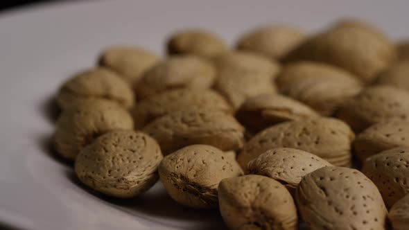 Cinematic, rotating shot of almonds on a white surface - ALMONDS