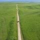 Top view on the driving car of the mountain road through the green field - VideoHive Item for Sale