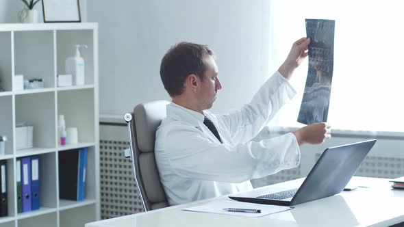 Professional medical doctor working in hospital office using computer technology.