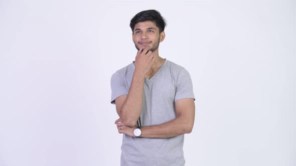 Young Happy Bearded Indian Man Smiling While Thinking