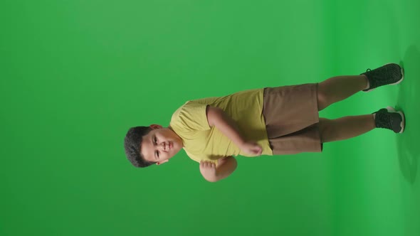 Full Body Of Funny Asian Little Boy Dancing In A Green Screen Studio