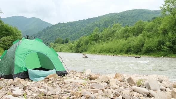 Beautiful Mountain Terrain and a Green Tent By the River
