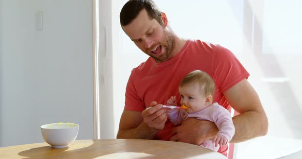 Father feeding his baby boy with spoon 