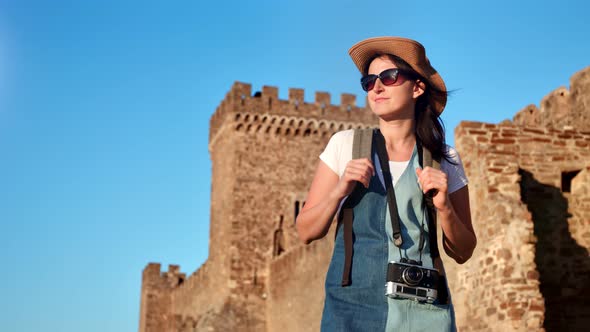 Smiling Hipster Backpacker Tourist Woman Relaxing at Medieval Castle Background Medium Shot