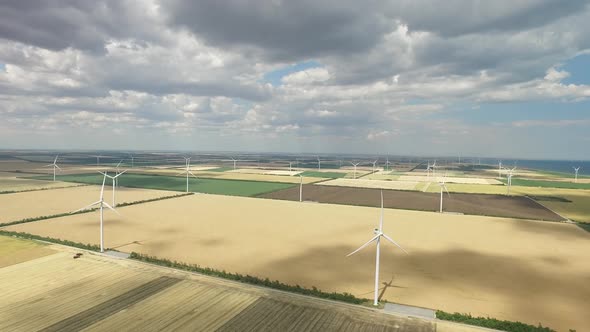 Wind Farms in Rural Areas Against the Background of Agricultural Fields Under a Blue Sky. Aerial