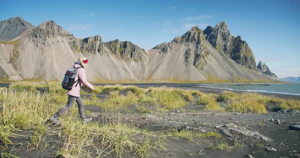 Morning Scene of Female Traveler Exploring Stokksnes Cape with Vestrahorn (Batman Mountain) on