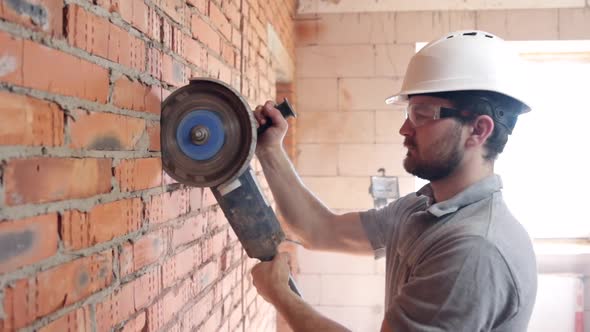 A construction worker with a circular saw in construction site.