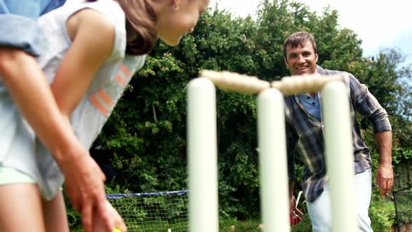 Happy family playing cricket