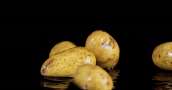 Fresh Raw Potatoes Falls Into the Water with Splashes. 