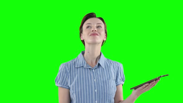 Caucasian woman using a digital tablet on green background