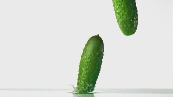 Super Slow Motion Cucumber Falls on the Water with Splashes