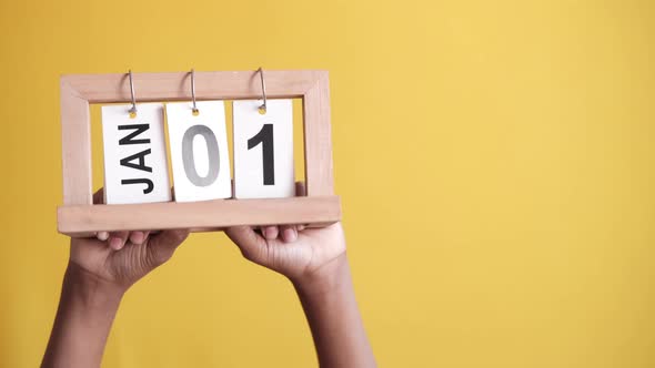 Wooden Calendar Set on 1St January on Yellow Background