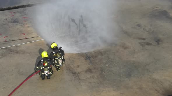 Top view the training of fireman team spray water to gas pipe in field of fireplace station