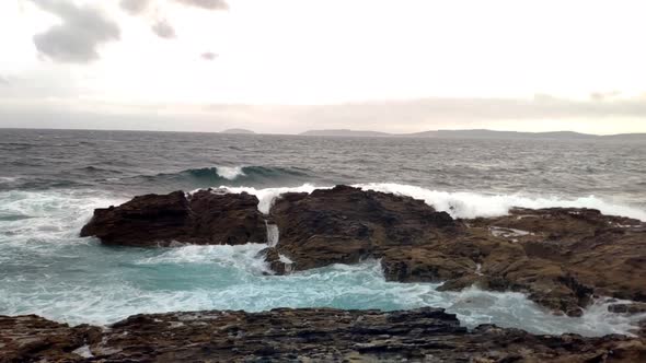 the sea on a windy and cloudy day with waves foaming against the rocks fast, dark storm clouds. Poin