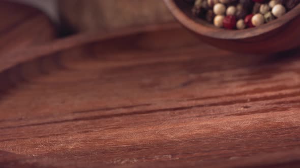 Colorful Pepper Falling on a Wooden Table