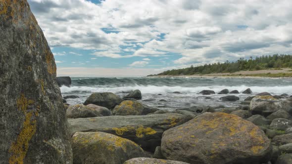 Time lapse: waves repeatedly crashing against rocky coast, tidal motion