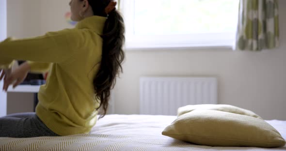 Super slow motion view of happy serene woman relaxing and diving on the bed