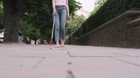 Young Blind Person with Long Cane Walking in a City