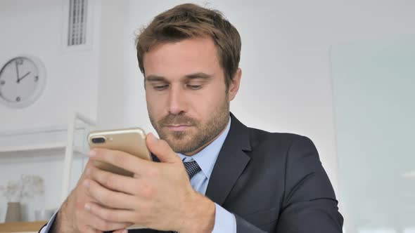 Close Up of Businessman Using Smartphone Wondering in Shock