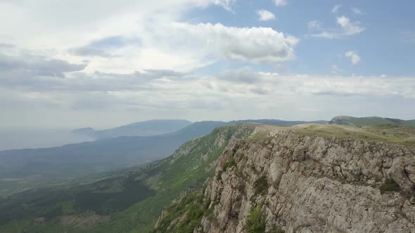 Flight Along a Cliff in Crimean Mountains. Amazing Aerial View of Rocks, Forests and Sea in Crimea