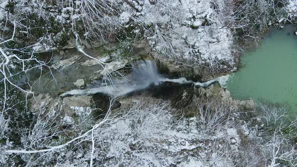 Waterfall Flowing From White Rocks Into a Lake in the Forest