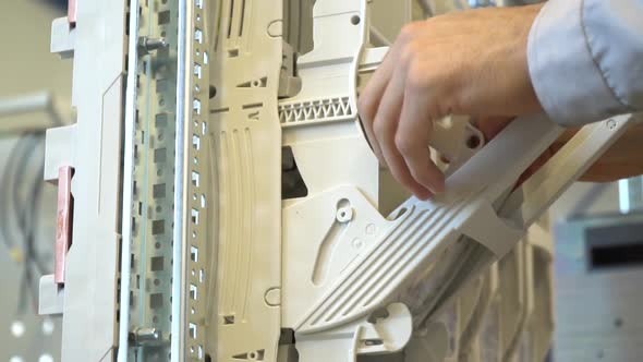 Electrician is Assembling an Electric Panel Attaching the Plastic Parts