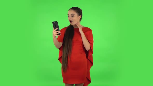 Pretty Young Woman Is Talking for Video Chat Using Mobile Phone and Rejoice. Green Screen