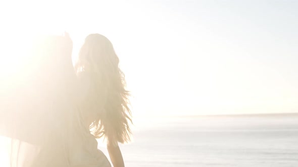 Woman Dancing In Bright Sunlight On Beach