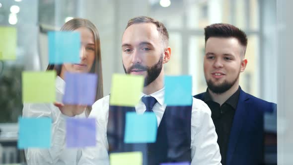 Attractive Businessman Working with Multi Colored Sticky Notes at Office Planning and Brainstorming