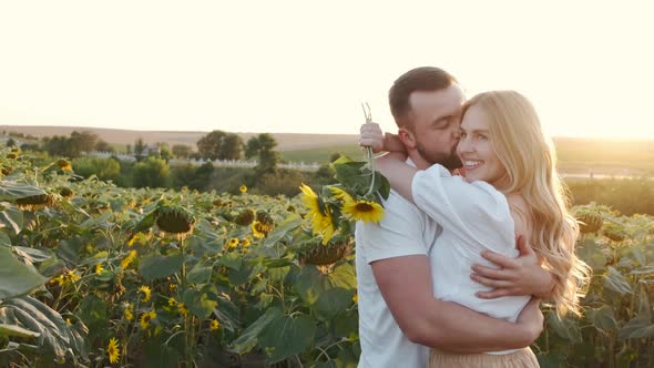 Handsome Man and Woman Hug at the Sunflower Field