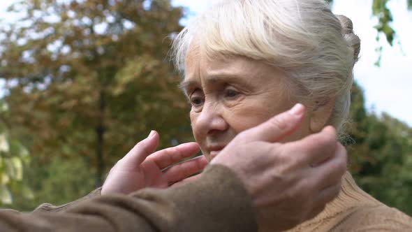 Tender Male Hands Calming and Comforting Mature Woman Holding Her Face, Close-Up