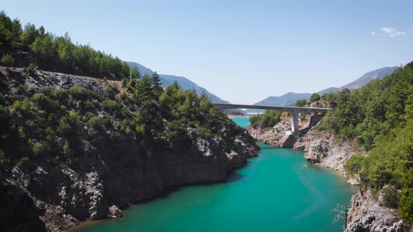 River through the mountain. bridge in the distance in the summer time.