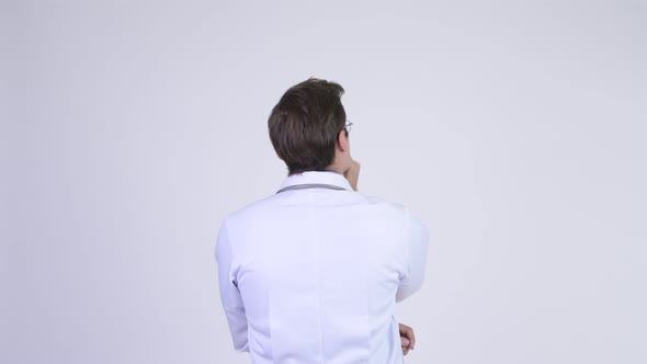 Rear View of Young Man Doctor Pointing Up