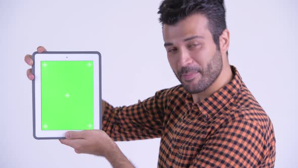 Face of Happy Bearded Persian Hipster Man Showing Digital Tablet