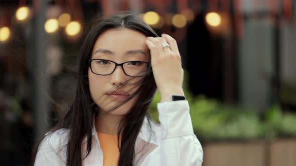 Portrait of Asian Girl in Eyeglasses Looking Into Camera