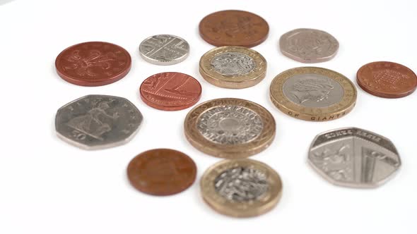 UK Currency pounds coins rotating close up footage against the white background