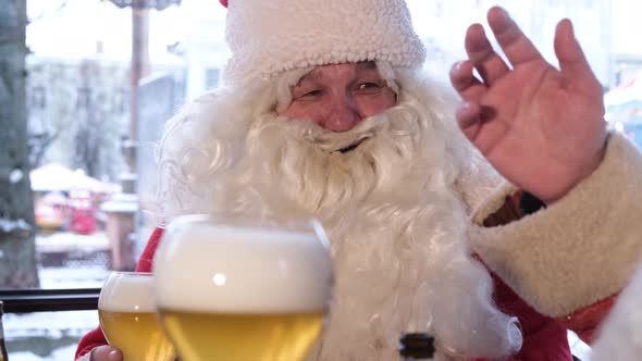 Friends in Santa Claus Costumes are Having Fun at a New Year's Party Drinking Beer in a Pub