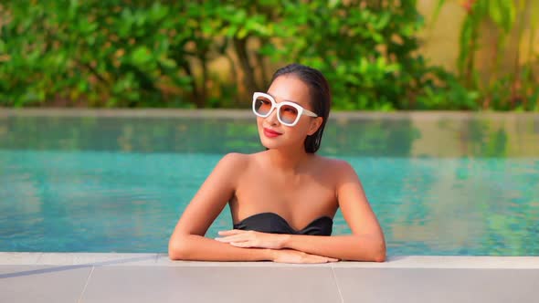 Young asian woman enjoy around outdoor swimming pool for leisure