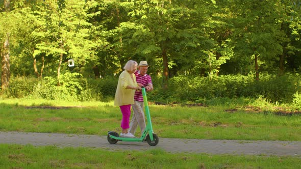 Senior Old Stylish Tourists Grandmother Grandfather Using Electric Scooter Enjoying Learning Ride