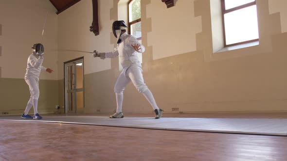 Fencer athletes during a fencing training in a gym