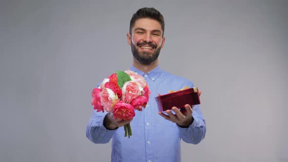 Happy Young Man with Bunch of Flowers and Gift Box