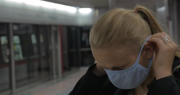 Woman Putting on Mask in the Subway