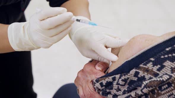 Paramedic giving people the COVID-19 vaccine injection during the vaccination operation