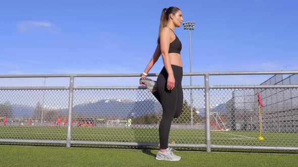 Athletic woman stretching leg before workout wide shot