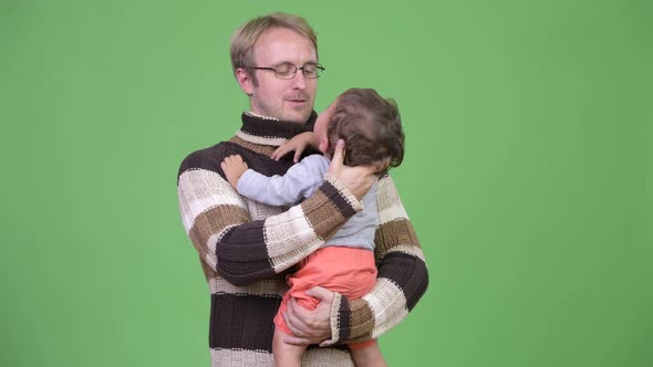 Studio Shot of Father Holding His Crying Baby Son