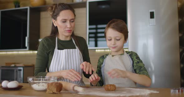 Young Family Mother and Son Making Homemade Cookies at Kitchen Table