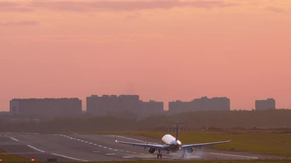 Rear View of a Plane Landing at Sunset