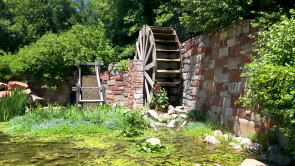 A picturesque watermill in a pond in a garden